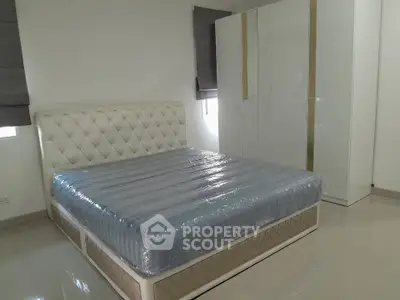 Spacious bedroom with elegant bed and modern wardrobe in a stylish apartment.