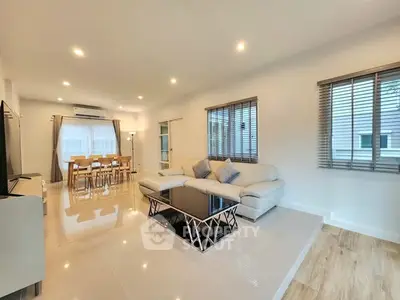 Spacious modern living room with elegant dining area and natural light.