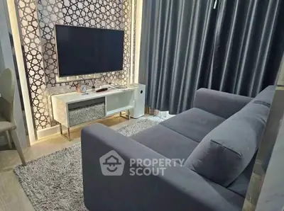 Modern living room with stylish decor, featuring a sleek sofa and large TV for ultimate comfort and entertainment.