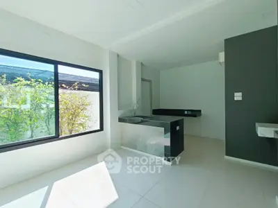 Modern kitchen with sleek design and large window offering natural light