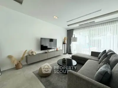 Modern living room with sleek furniture and large window, perfect for relaxation.