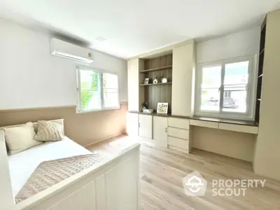 Bright and airy bedroom with modern built-in storage and large windows.