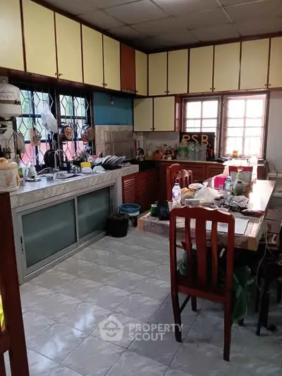Spacious kitchen with ample storage and dining area, featuring a closed layout and natural light.