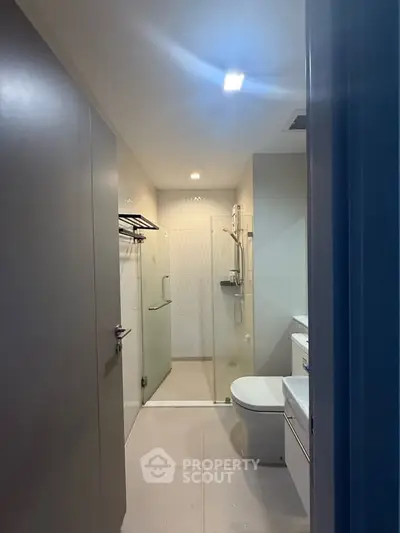 Modern bathroom with glass shower and sleek fixtures in a contemporary apartment.