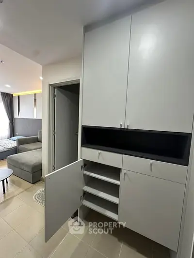 Modern apartment interior with sleek storage cabinet and cozy living area.