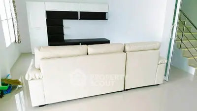 Modern living room with sleek white sofa and minimalist shelving unit