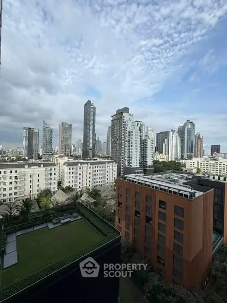 Stunning cityscape view from a high-rise building with lush green rooftop garden.