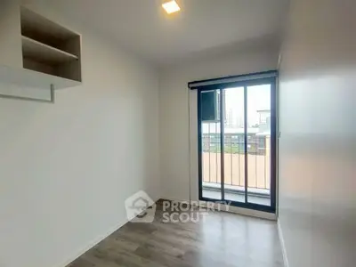 Bright and airy bedroom with large window and balcony access in modern apartment.