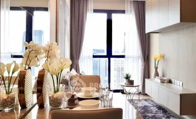 Elegantly furnished dining area with a modern aesthetic, featuring a stylish table set for four, complemented by chic decor and natural light from floor-to-ceiling windows, offering a glimpse of the cityscape.
