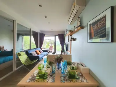 Spacious living room with dining area and balcony view, featuring modern decor and ample natural light.