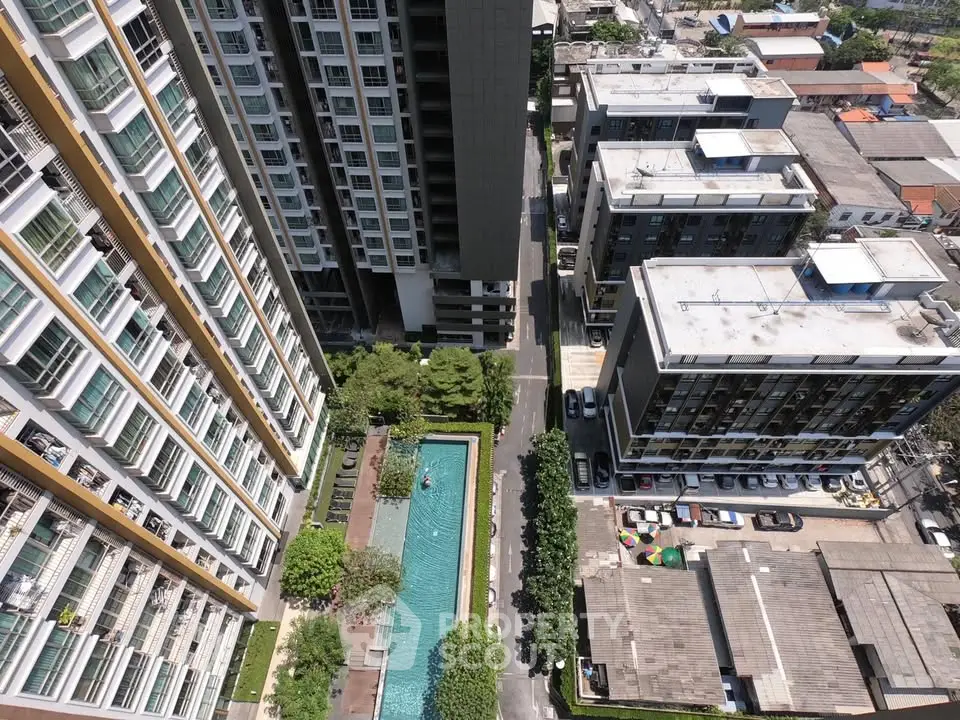 Aerial view of modern apartment complex with swimming pool and parking area.