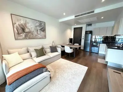 Modern living room with stylish decor and open kitchen layout, featuring cozy seating and elegant dining area.