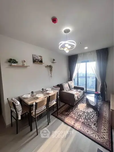 Modern living room with stylish decor and balcony view, featuring a cozy dining area and elegant lighting.