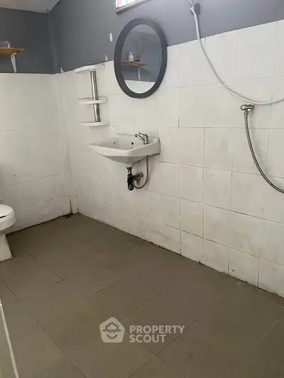Minimalist bathroom with wall-mounted sink and shower, ideal for compact spaces.