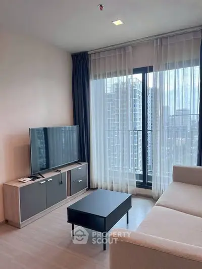 Modern living room with city view, featuring sleek furniture and large windows.