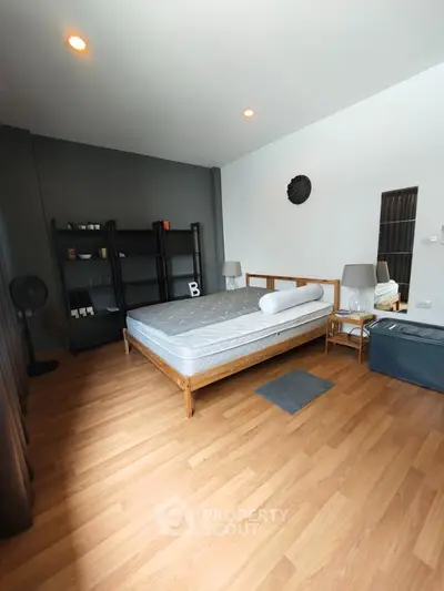 Spacious modern bedroom with wooden flooring and stylish decor