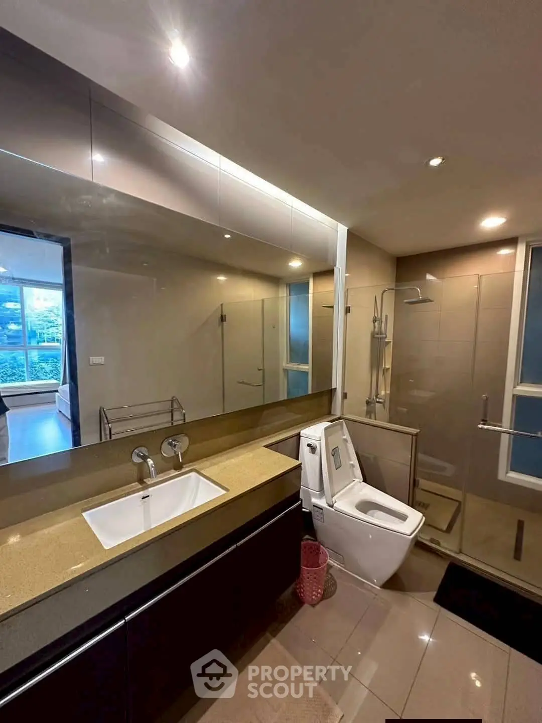 Modern bathroom with sleek fixtures and glass shower enclosure in a luxury apartment.
