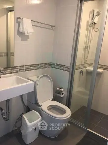 Modern bathroom with shower and sleek fixtures in contemporary apartment.