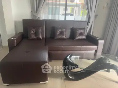 Modern living room with sleek brown leather sofa and stylish glass coffee table.