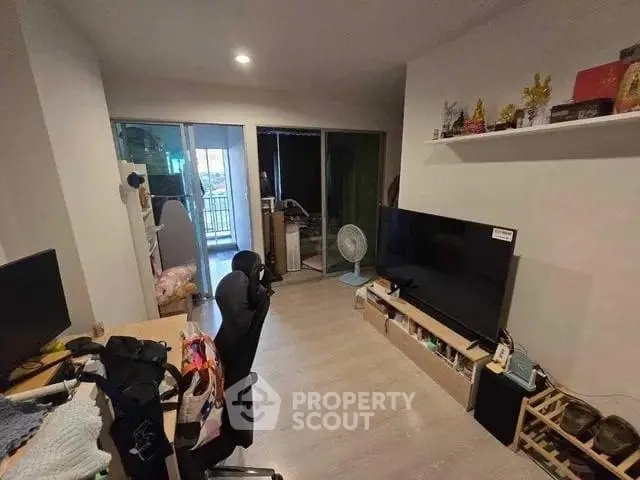 Cozy living room with modern decor and large TV, perfect for relaxation.