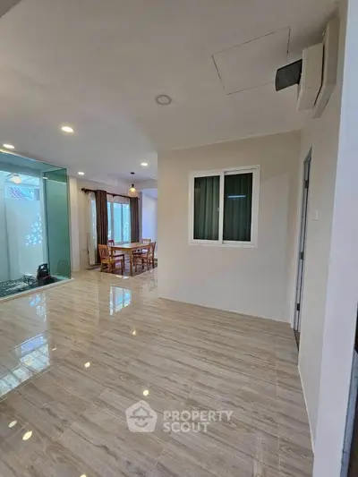 Spacious open-plan living area with modern flooring and dining space, perfect for family gatherings.