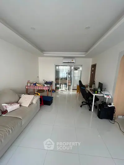 Spacious living room with modern decor and ample natural light, perfect for family gatherings.