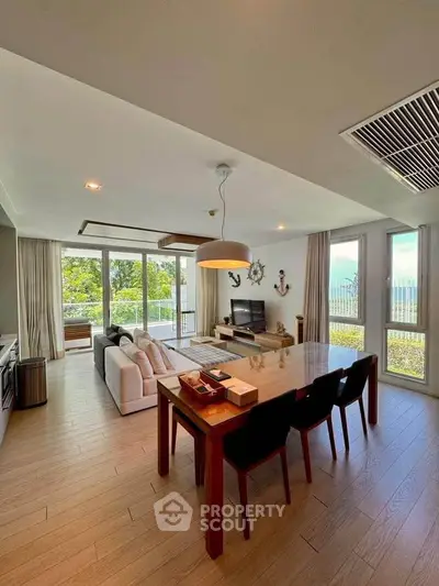 Spacious modern living room with open layout and large windows offering a stunning view.