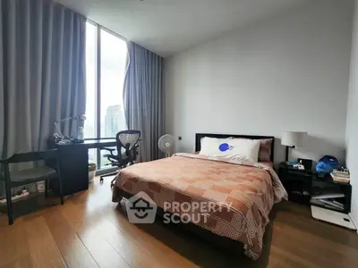 Modern bedroom with city view, featuring a cozy bed, study desk, and floor-to-ceiling windows.