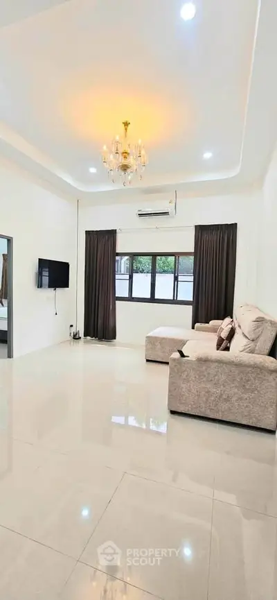 Spacious living room with elegant chandelier and modern furnishings