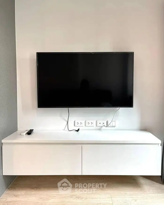 Modern living room with wall-mounted TV and sleek white console