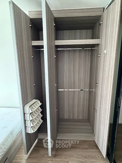 Spacious modern wardrobe with wooden finish and ample storage space in a stylish bedroom.