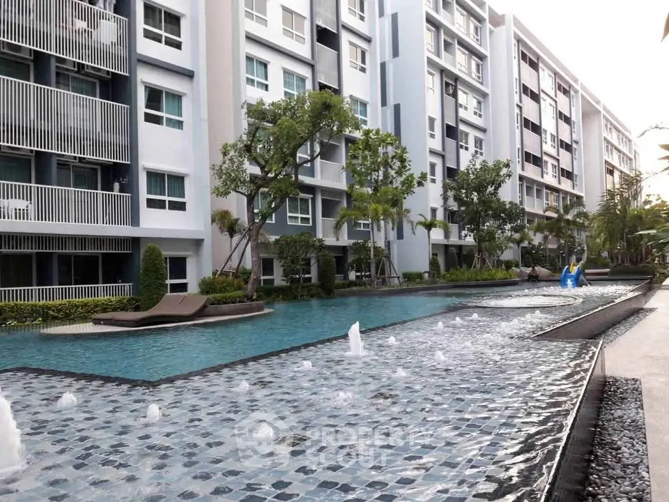 Luxurious apartment complex with stunning pool and modern architecture.
