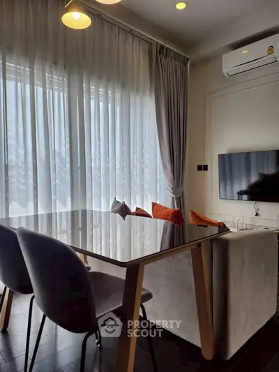 Modern living room with sleek furniture and large window drapes