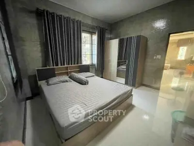 Spacious bedroom with modern decor and ample natural light.