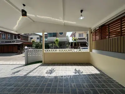 Spacious covered patio with modern tiles and natural light, perfect for outdoor relaxation.