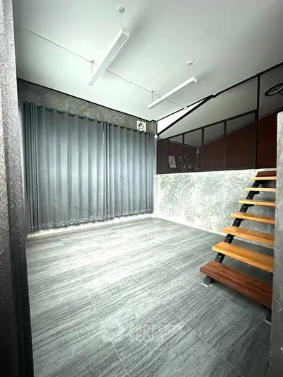 Modern minimalist interior with sleek staircase and large windows, perfect for contemporary living.