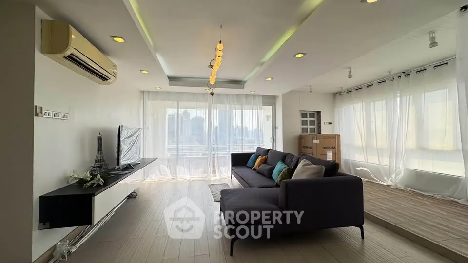 Spacious modern living room with elegant decor and panoramic city views.
