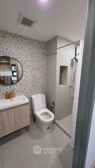 Modern bathroom with terrazzo wall, sleek vanity, and walk-in shower
