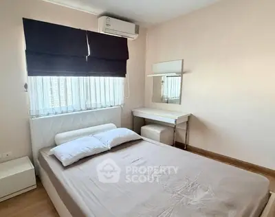 Cozy bedroom with modern furnishings and natural light, featuring a comfortable bed and stylish decor.