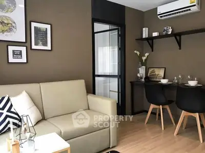 Modern living room with beige sofa, wall art, and dining area in stylish apartment.