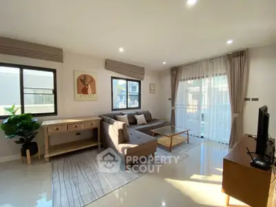 Bright and spacious living room with modern decor and large windows.
