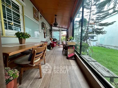 Charming enclosed balcony with wooden ceiling and garden view, perfect for relaxation and entertaining.
