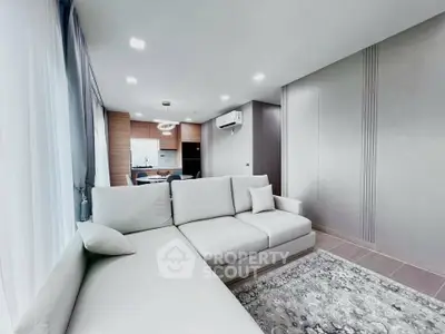 Modern living room with elegant sofa and open kitchen layout