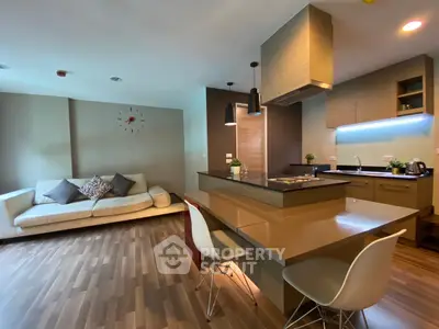 Modern open-layout kitchen and living room with stylish decor and wooden flooring.