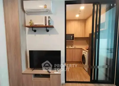 Modern apartment interior with living room and kitchen featuring air conditioning and washing machine.
