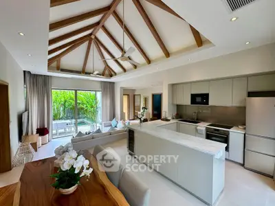 Luxurious open-plan living room with high ceilings and modern kitchen, featuring a stunning garden view.
