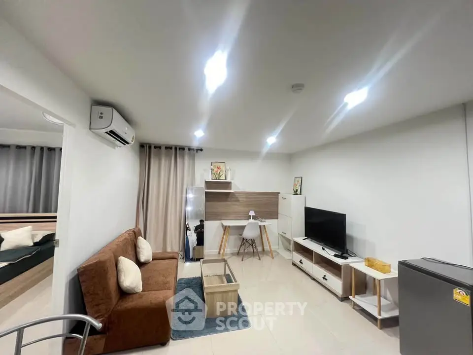 Modern living room with cozy sofa, TV, and stylish decor in a bright apartment.