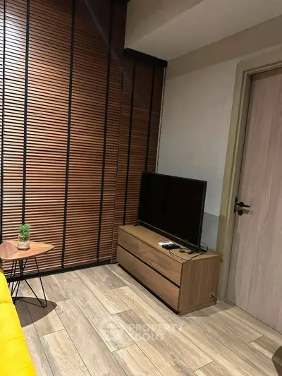 Modern living room with wooden flooring, sleek TV stand, and stylish decor