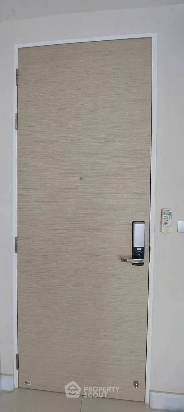 Modern apartment entrance with electronic lock and minimalist design.