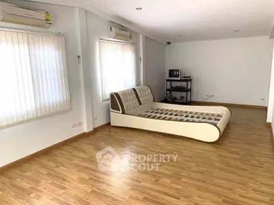 Spacious bedroom with modern bed frame and wooden flooring